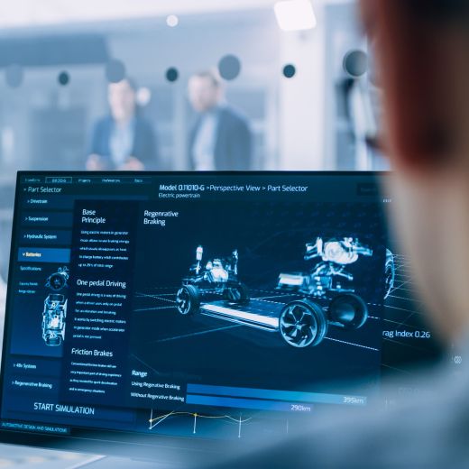 Un homme fixe l'écran d'une tablette montrant l'image d'une voiture électrique.